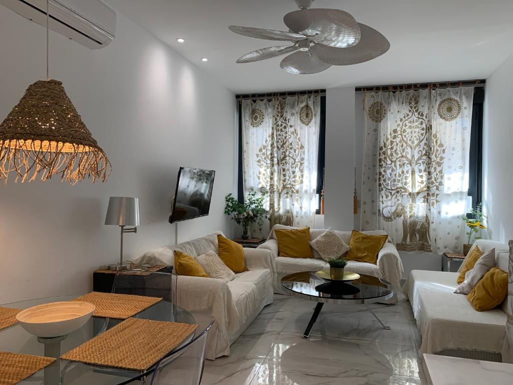 un soggiorno con mobili bianchi e ventilatore a soffitto di Apartamento NEPTUNO con piscina a 50 mt de la playa a El Morche