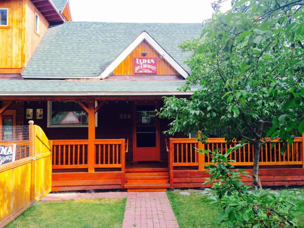 una casa con un porche de madera con un cartel en Luna Bed & Breakfast, en Grand Forks