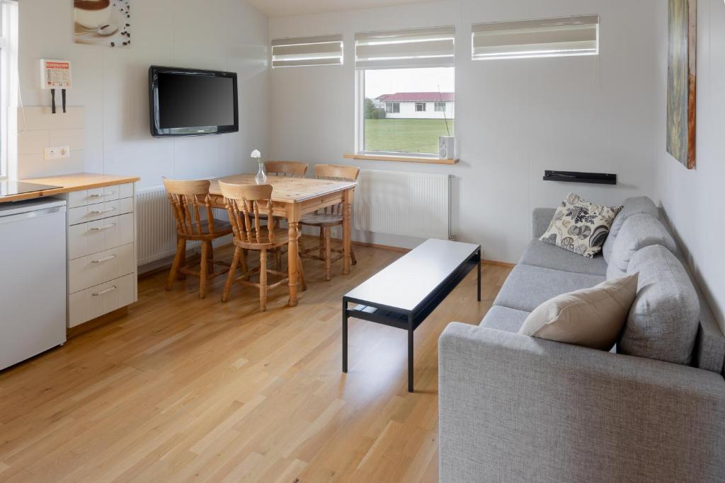 ein Wohnzimmer mit einem Sofa und einem Tisch in der Unterkunft South Central Country-Apartment in Brautarholt
