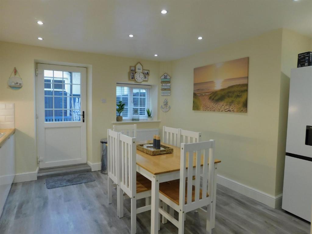 a kitchen with a table and chairs and a refrigerator at St Christophers Cottage, Sheringham - Keys Holiday Cottages in Sheringham