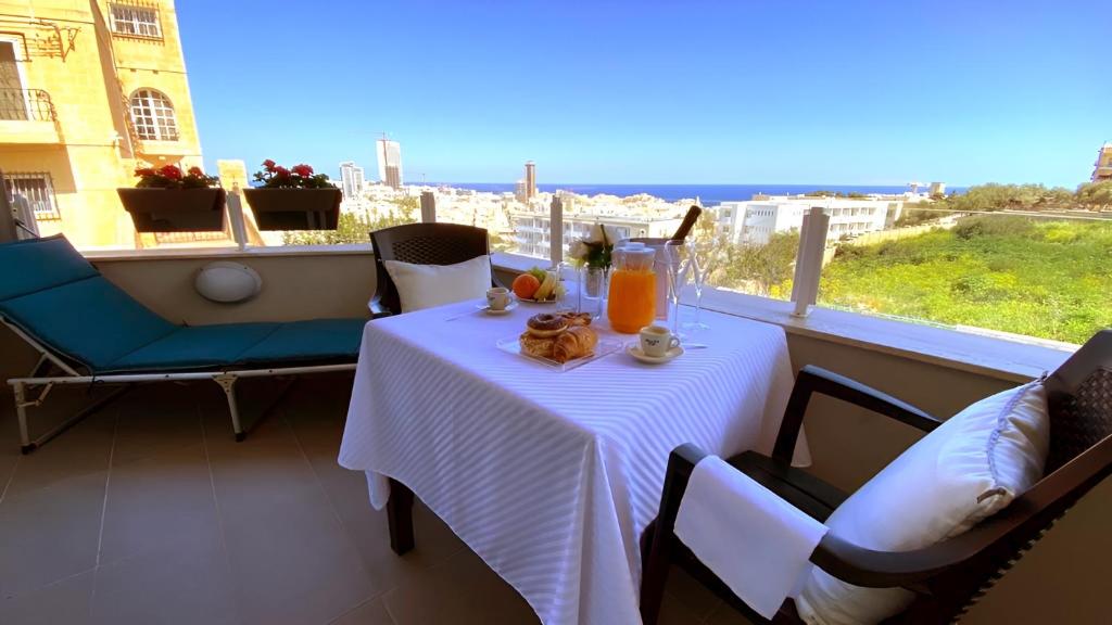 un tavolo sul balcone con vista sulla città di St. Julian's Super Bright And Spacious Seaview Apartment a San Giuliano