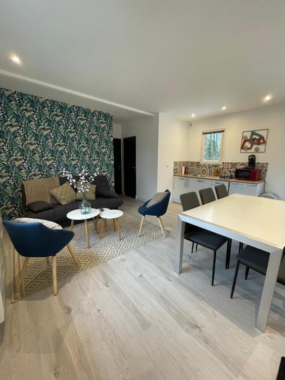 ein Wohnzimmer mit einem Sofa, einem Tisch und Stühlen in der Unterkunft Les Chalets du Mancel - Chalet Victor - 500 m Bouleries Jump , 10 min du circuit des 24h in Parence