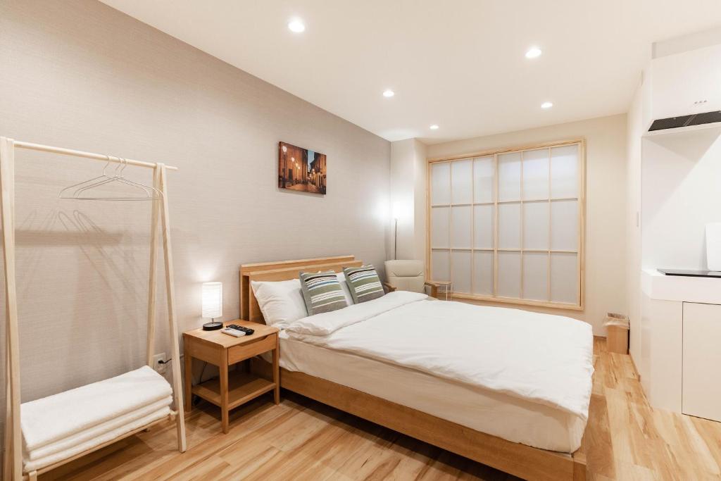 een kleine slaapkamer met een bed en een raam bij 大阪道顿堀 铁甲猫の家 in Osaka