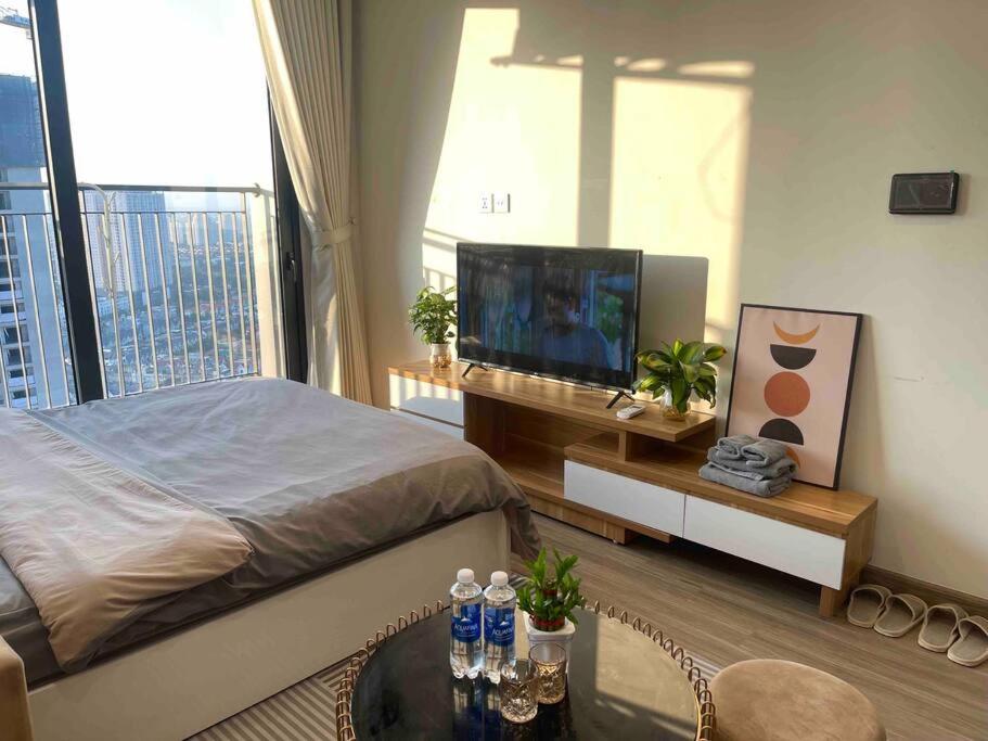 a bedroom with a bed and a flat screen tv at Vinhomes Smart City - Căn hộ Studio cao cấp tại tòa SA3 in Hanoi