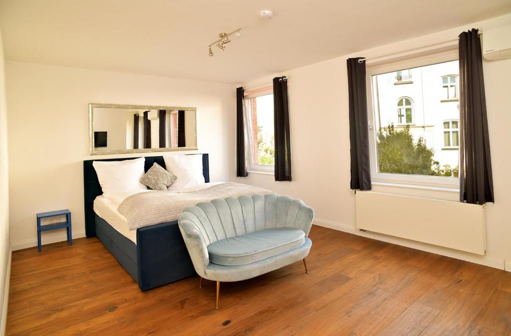 Un dormitorio con una cama y una silla y una ventana. en Victoria Boardinghouse, en Düsseldorf