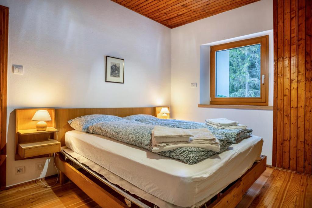 Schlafzimmer mit einem Bett und einem Fenster in der Unterkunft Villa la Brisa 2 in Predazzo