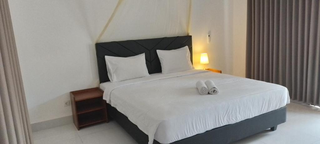 ein Schlafzimmer mit einem großen Bett und zwei weißen Handtüchern in der Unterkunft parida bungalow in Gili Air