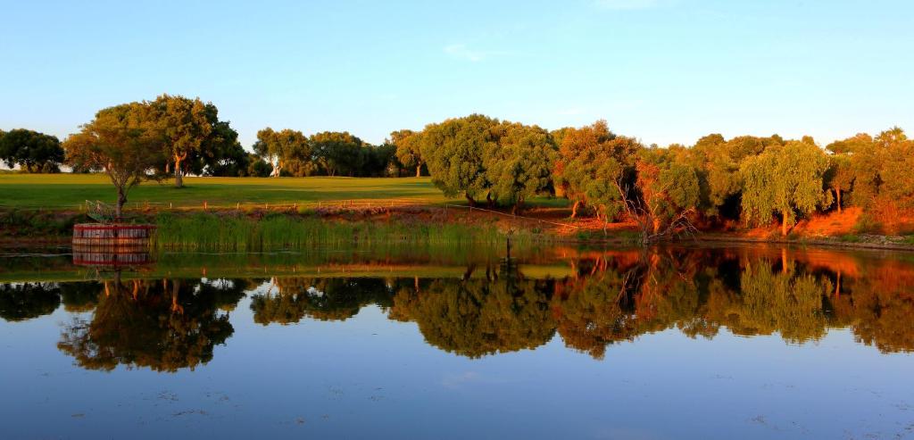 a reflection of a golf course in the water at Hotel Hacienda Montenmedio in Vejer de la Frontera