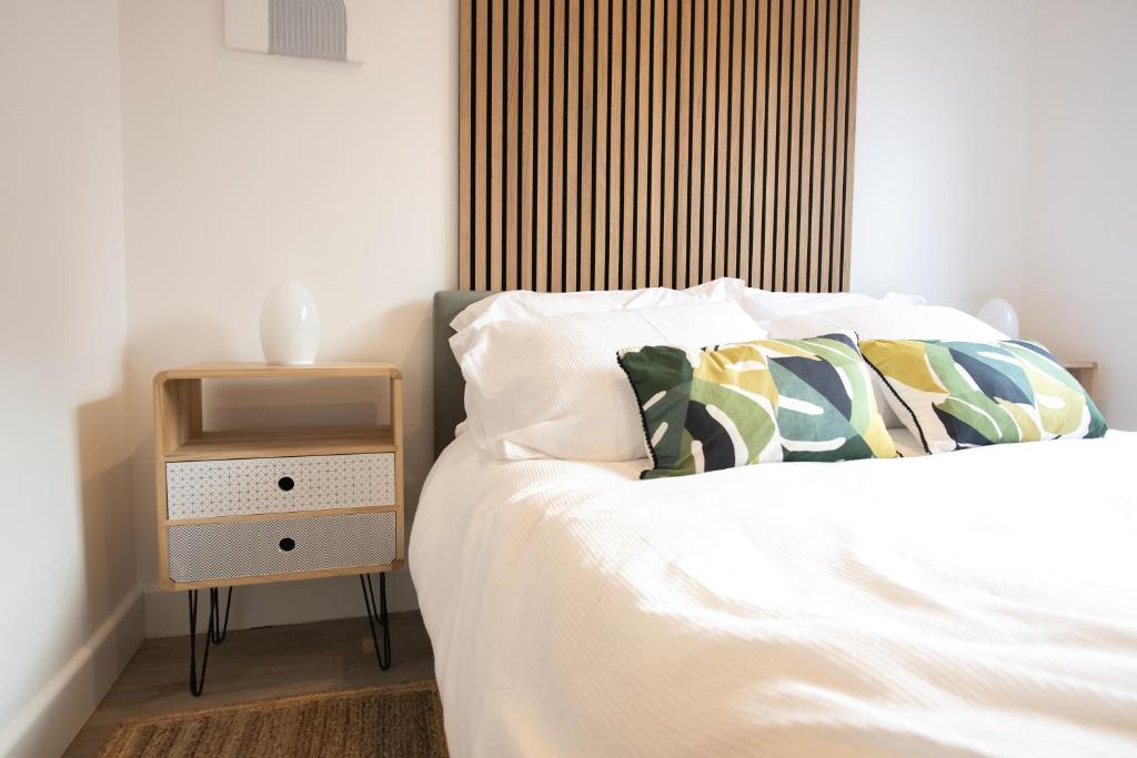 a bedroom with a bed with a night stand next to it at Dorset Stylish Apartment in Poole