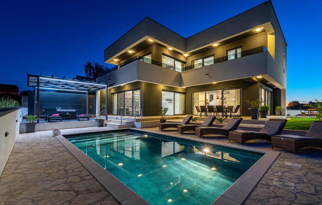 Una casa grande con piscina delante de ella. en Villa Evoque - Adriatic Luxury Villas, en Zadar