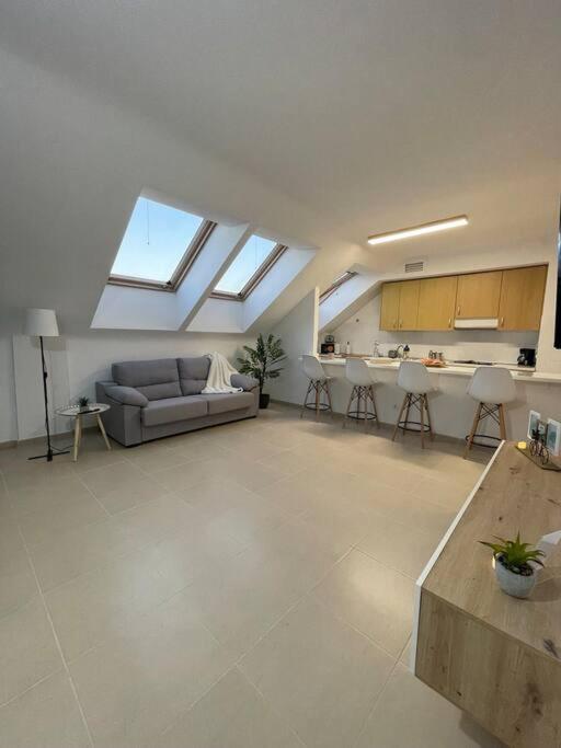 a large living room with a couch and a kitchen at La Buhardilla in Moya