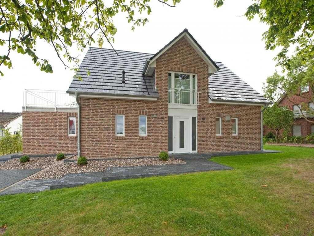 a brick house with a window and a yard at Auszeit Ferienhaus in Groß Schwansee