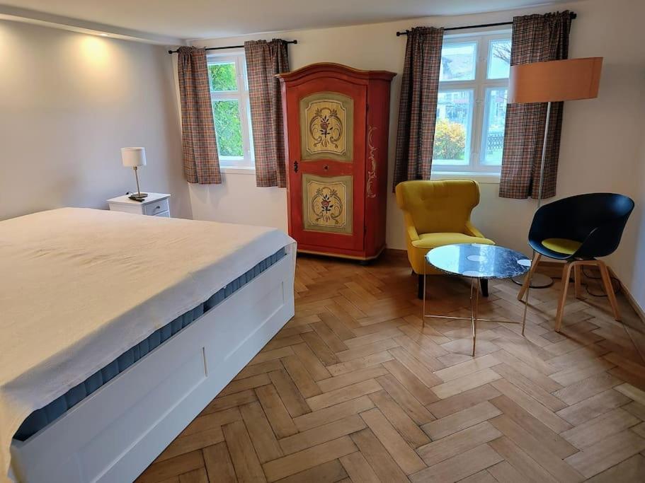 上斯陶芬的住宿－Ferienwohnung RESL - geschmackvoll renoviert & zentral im historischen Schindelhaus，一间卧室配有一张大床和一张桌子及椅子
