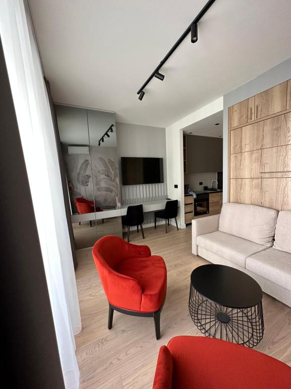 a living room with a red chair and a couch at BW Lux Apartments in Sajmište