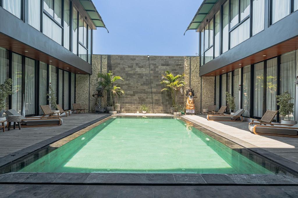 a swimming pool in the middle of a building at Forseti Athena in Seminyak