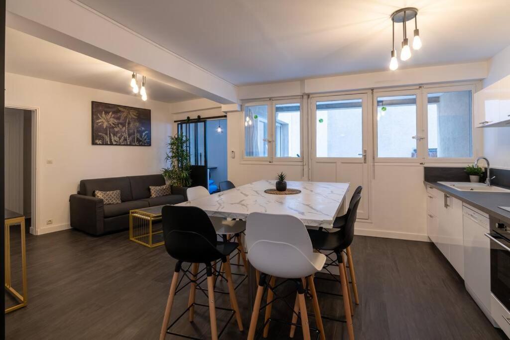 uma cozinha e sala de estar com mesa e cadeiras em Élégant T3 Le Petit Palais Avignon em Avignon