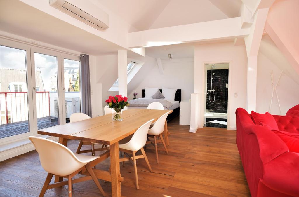 un soggiorno con tavolo in legno e divano rosso di Victoria Altstadt Boardinghouse a Dusseldorf