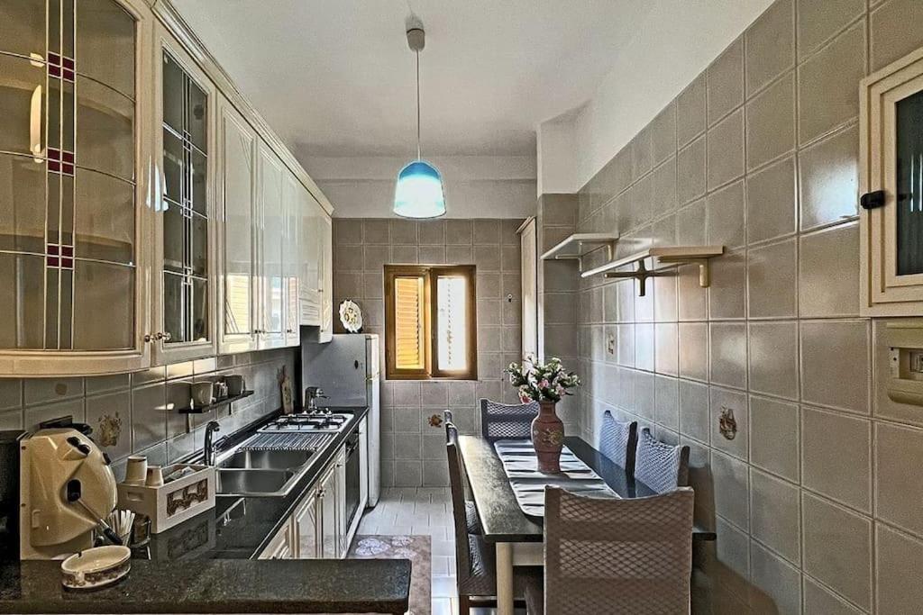 a kitchen with a sink and a table with chairs at Domus near Scavi di Poppea in Torre Annunziata