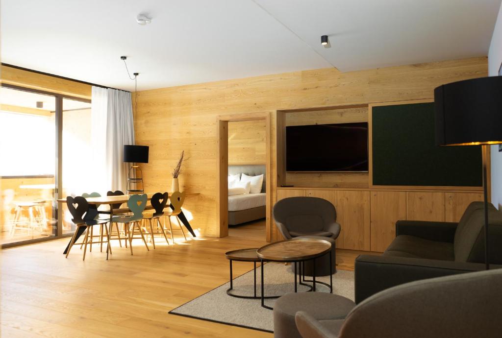 a living room with a tv and a table and chairs at Heimat 1495m Appartement TYP 5 in Schröcken