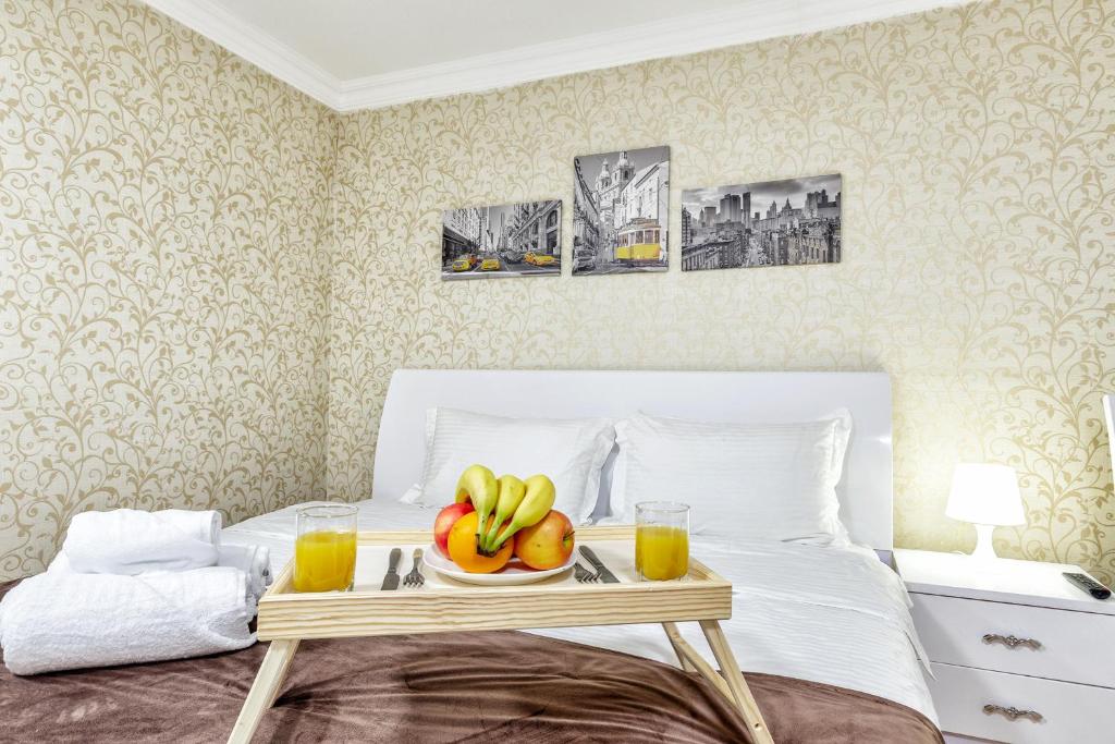 uma bandeja de frutas e bebidas numa cama em Hotel Bed and Breakfast em Astana