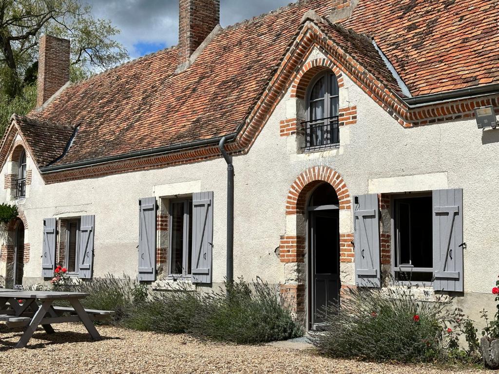 une maison blanche avec une table devant elle dans l'établissement Longère en Sologne 2, à La Boullaye