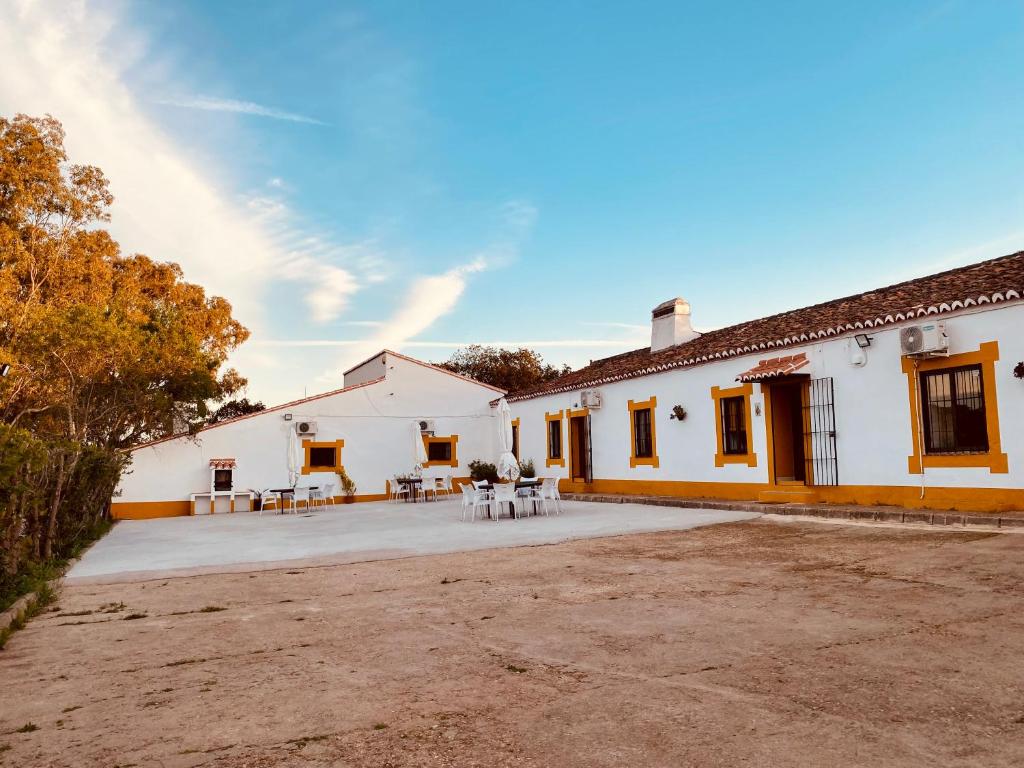 a large white building with tables and chairs in the courtyard at Complejo Rural Los Molinos 