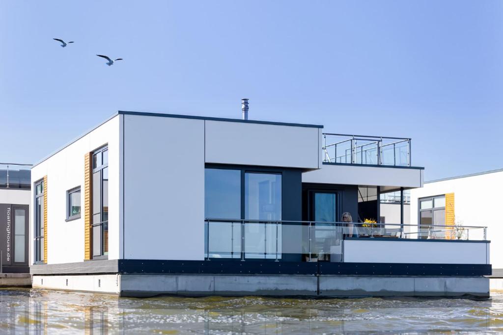 ein Haus auf einem Fluss mit Wasser in der Unterkunft Floatinghouses BernsteinResort in Ribnitz-Damgarten