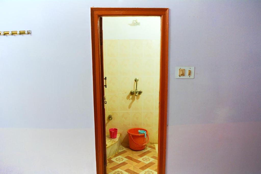 a bathroom with a shower with a toilet and a mirror at Hostel shivshakti khajuraho in Khajurāho