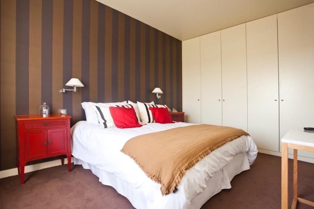 - une chambre avec un grand lit et une table de chevet rouge dans l'établissement Biarritz - le Regina - proche phare, à Biarritz