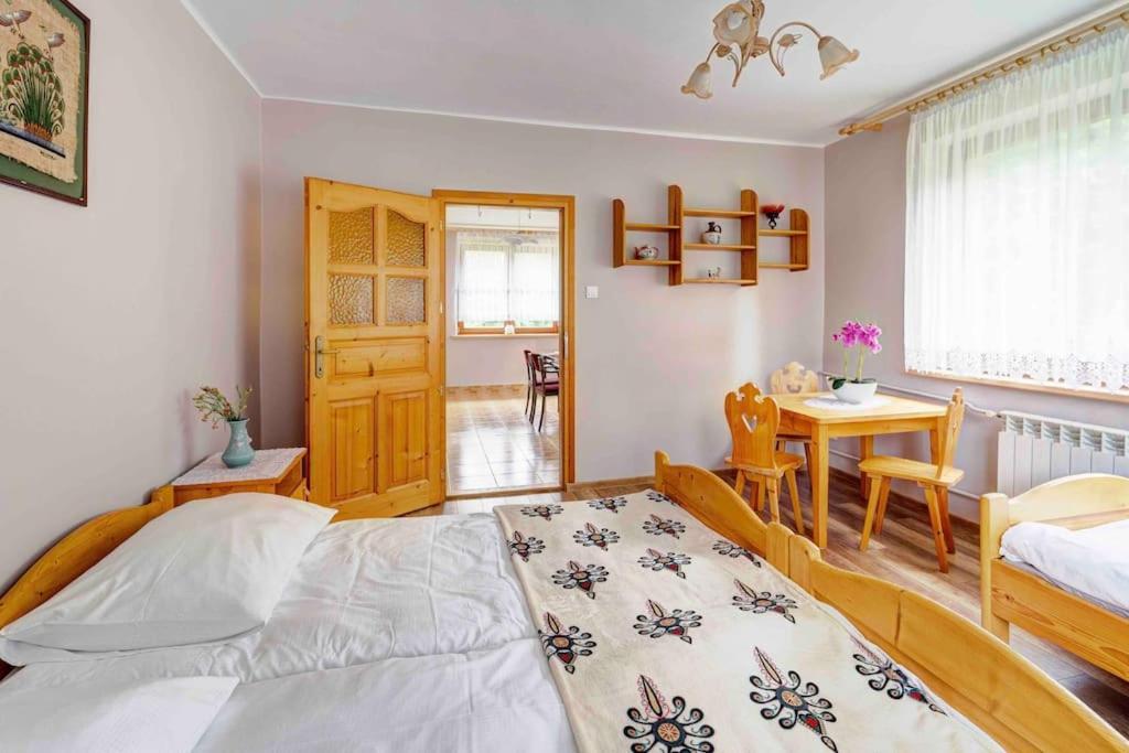 - une chambre avec un lit et une table dans l'établissement Leśny Domek, à Obidowa
