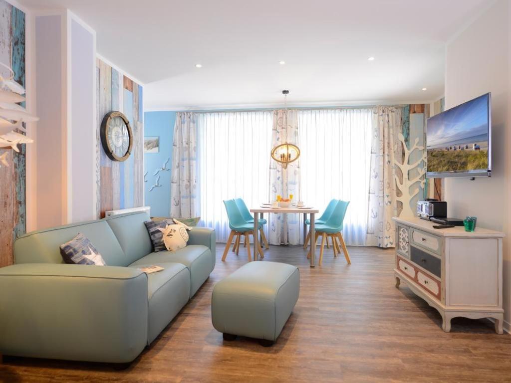 a living room with a couch and a table with chairs at Florida App 1 Montag in Boltenhagen