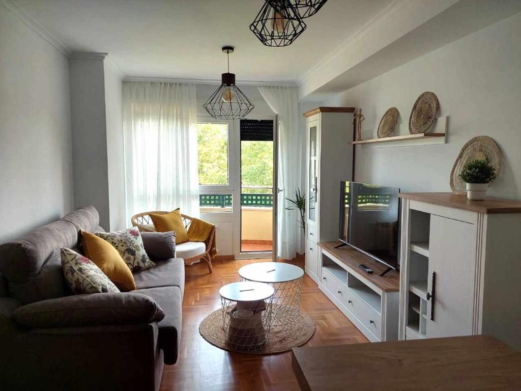 a living room with a couch and a tv at La Marina Posada de LLanes VUT-3648-AS in Posada de Llanes