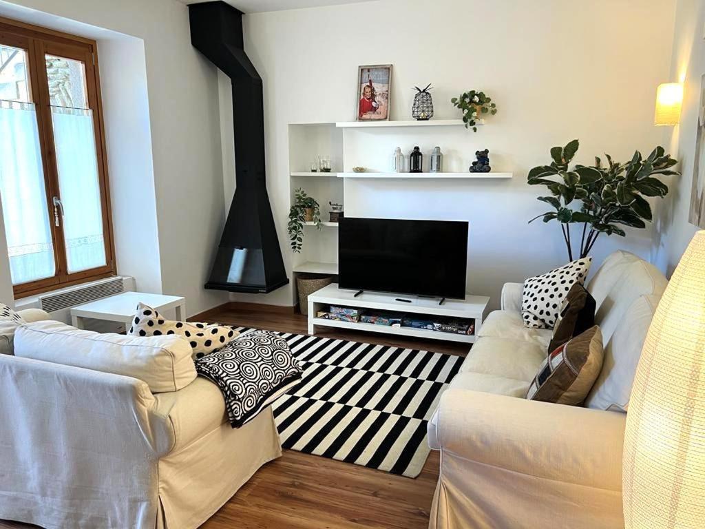 a living room with two white couches and a television at Bonita Planta baja en Err con wifi in Err