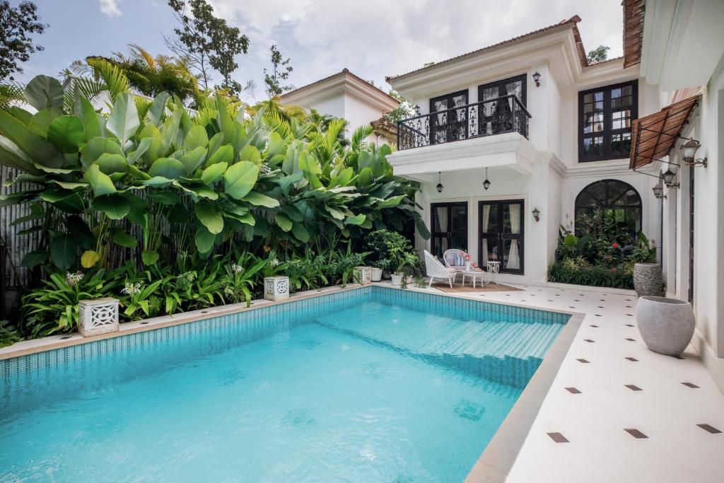 a swimming pool in the backyard of a house at LohonoStays Castello Villa 5 in Vagator