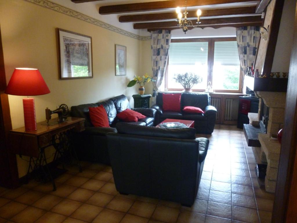 a living room with a black couch and red pillows at Les Chambres De Solgne in Solgne