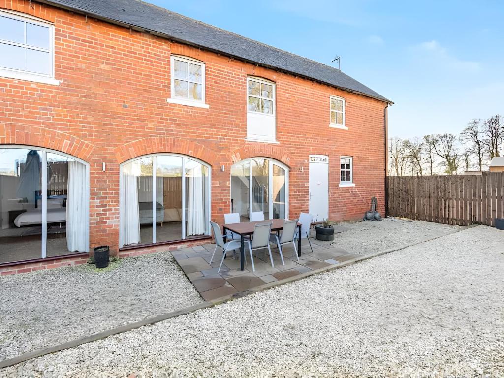 a brick house with a table and chairs in front of it at The Granary, Wolds Way Holiday Cottages, spacious 3 bed cottage in Cottingham