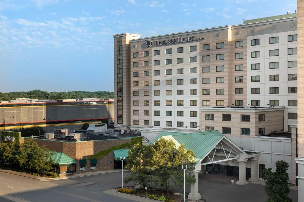 a large white hotel building with a parking lot at DoubleTree by Hilton Chicago O'Hare Airport-Rosemont in Rosemont