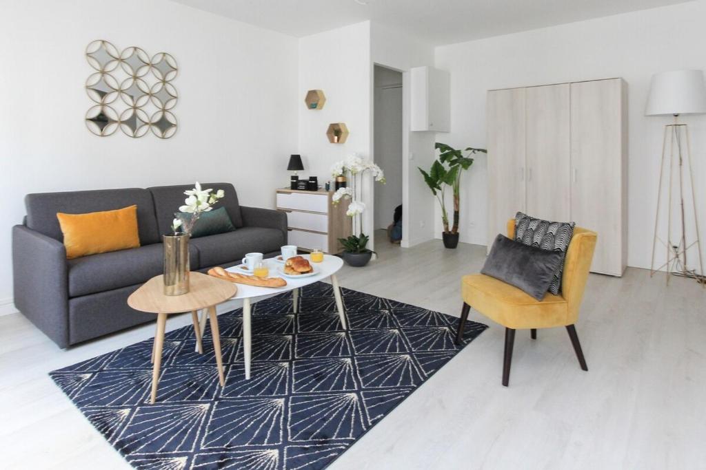 uma sala de estar com um sofá, uma mesa e cadeiras em Paris - Studio - Pere-Lachaise em Paris
