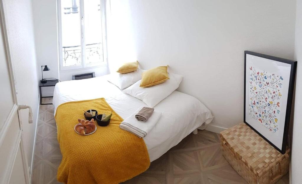 - une chambre avec un lit blanc et une couverture jaune dans l'établissement Bastille - Lappe - Quartier anime, à Paris