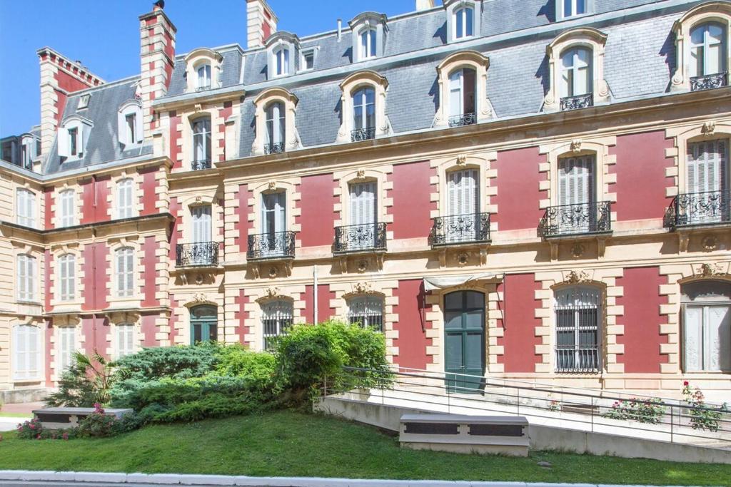 a large building with benches in front of it at Biarritz - Clemenceau - Centre ville - Plage in Biarritz