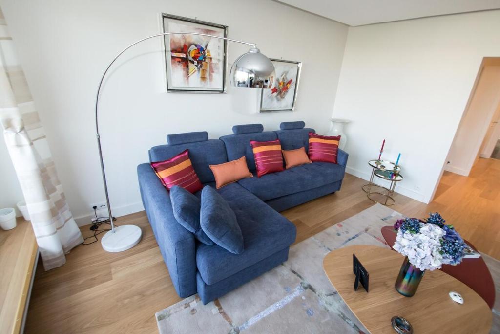 un salon avec un canapé bleu et une table dans l'établissement Luxueux pied à terre -Trocadéro - Tour Eiffel et Champs de Mars, à Paris