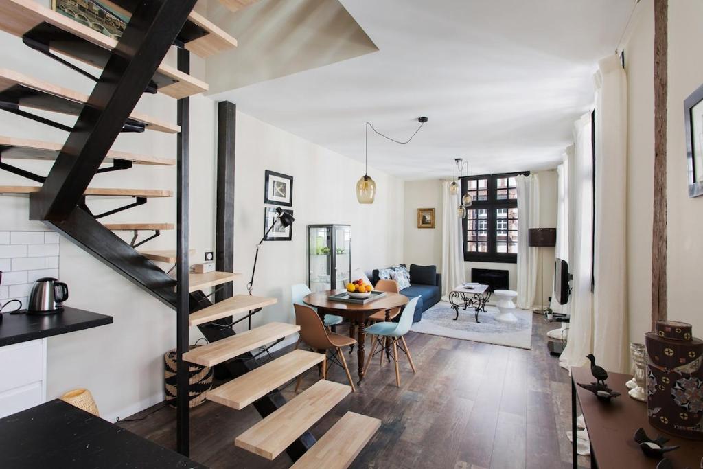 a living room with a spiral staircase and a table at Bayonne - Centre ville - Triplex - Standing in Bayonne
