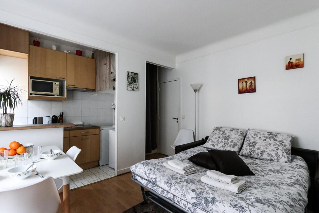 a living room with a bed and a kitchen at Paris 15eme - Porte de versailles - Vaugirard in Paris
