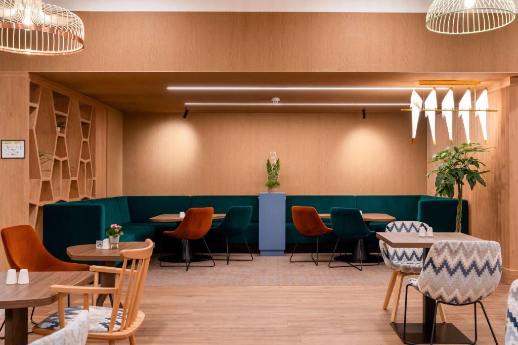 a dining room with green tables and chairs at Hampton By Hilton Budapest City Centre in Budapest