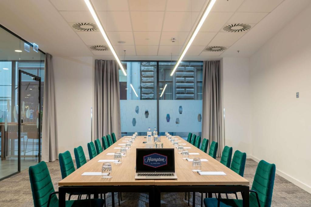 a conference room with a long table with a laptop on it at Hampton By Hilton Budapest City Centre in Budapest