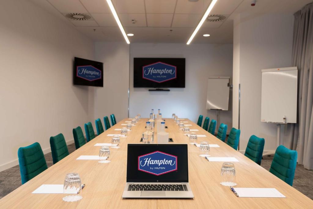 a conference room with a long table with a laptop on it at Hampton By Hilton Budapest City Centre in Budapest