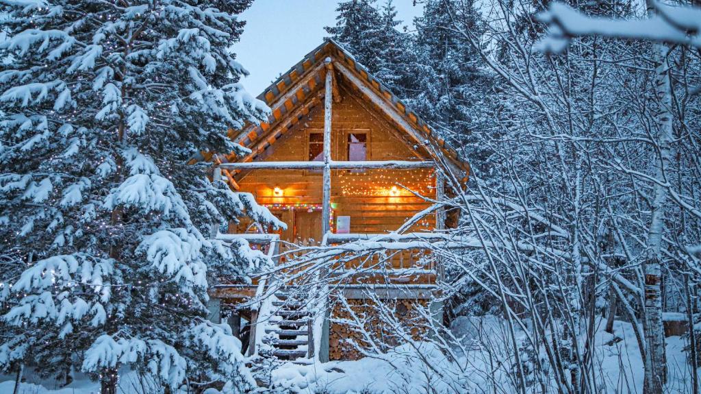 a log cabin in the woods in the snow at Mestia Eco Huts in Mestia