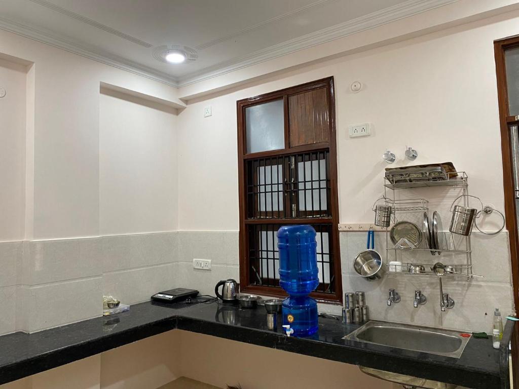 a kitchen with a sink and a blue bottle on a counter at Shri Ram Paying Guest House in Varanasi