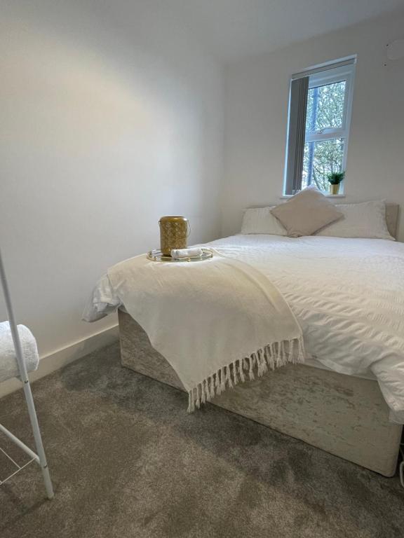 a bedroom with a white bed with a window at Manchester City luxury hideaway in Urmston