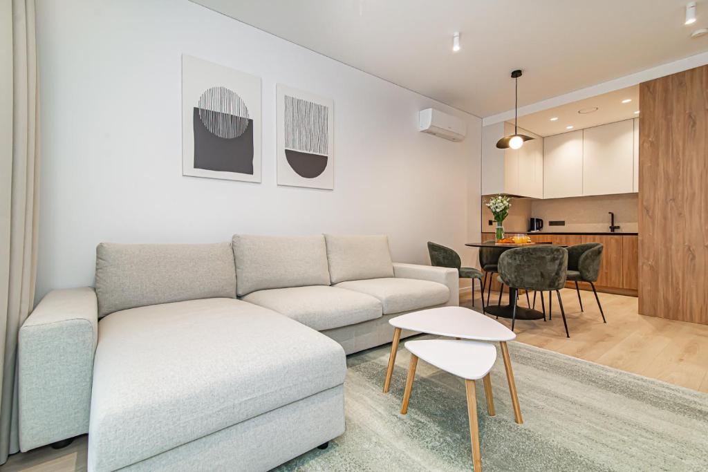 a living room with a couch and a table at #stayhere - New & Stylish Minimalistic 1BDR Vilnius City Center in Vilnius
